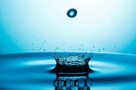 drop of water falling down in the waterの写真素材