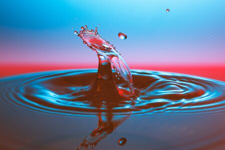 drop of water falling down in the waterの写真素材