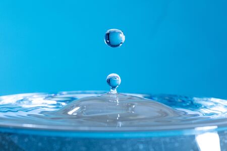 drop of water falling down in the waterの写真素材