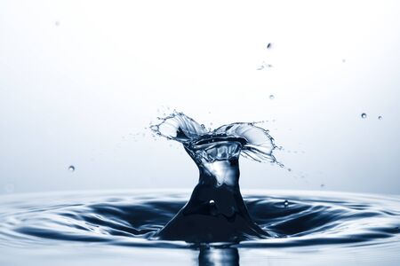 drop of water falling down in the waterの写真素材