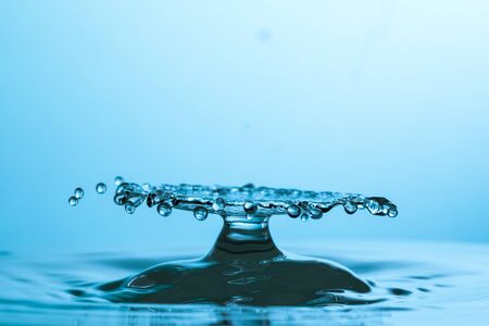 drop of water falling down in the waterの写真素材