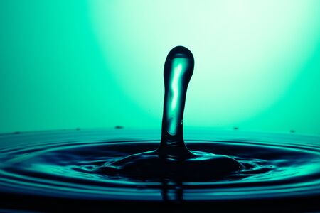 drop of water falling down in the waterの写真素材