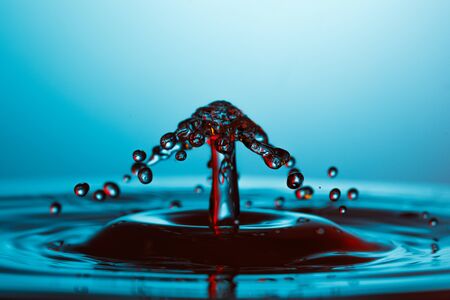 drop of water falling down in the waterの写真素材