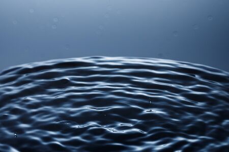 drop of water falling down in the waterの写真素材
