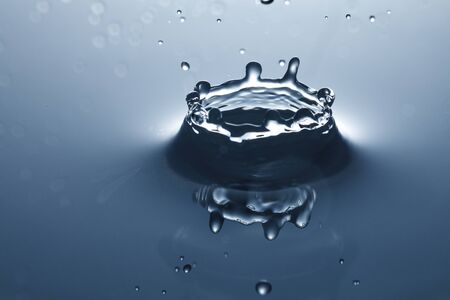 drop of water falling down in the waterの写真素材