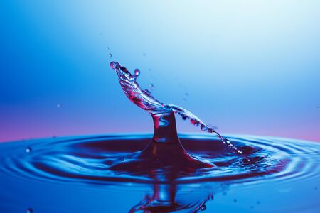 drop of water falling down in the waterの写真素材