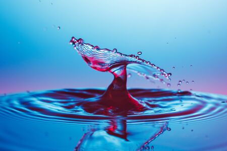 drop of water falling down in the waterの写真素材