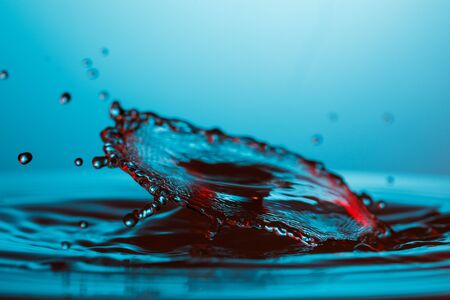 drop of water falling down in the waterの写真素材