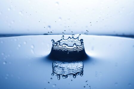 drop of water falling down in the waterの写真素材