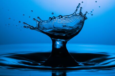 drop of water falling down in the waterの写真素材