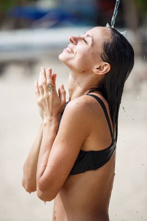 beautiful girl takes a shower on the beachの写真素材