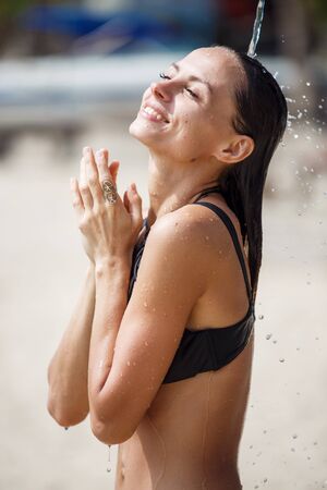 beautiful girl takes a shower on the beachの写真素材