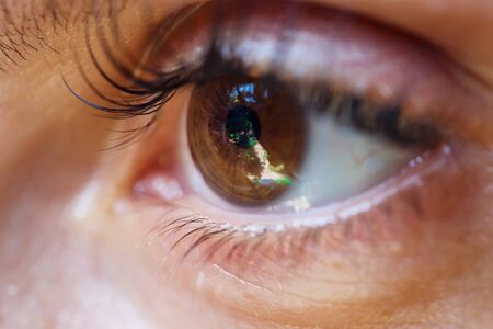 girls brown eye with a reflection in itの写真素材