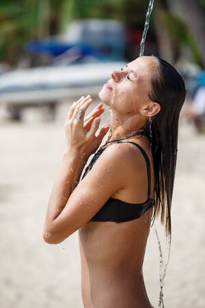 beautiful girl takes a shower on the beachの写真素材