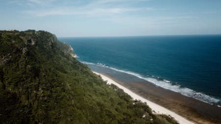Uluwatu cliff with crystal blue water and gold beach in Indonesia. Bali landscape from top view from a mountain peak. Travel paradise destination for a couple in searching for adventure.の写真素材