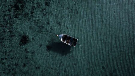 Lonely fisherman boat at the reef, in the middle of the ocean