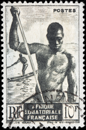 FRENCH EQUATORIAL AFRICA - CIRCA 1947: A stamp printed by FRANCE shows Boatman and African Pirogue, circa 1947のeditorial素材