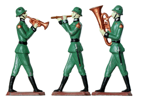 Set of three ancient tin toy soldiers. German armed by bayonets infantry soldiers from military wind orchestra against white background.の写真素材