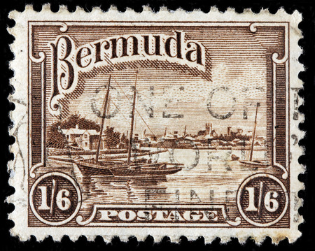 BERMUDA - CIRCA 1936: A stamp printed by BERMUDAS ISLES shows image of Port of Hamilton and sailing boat Song of the Wind, circa 1936のeditorial素材