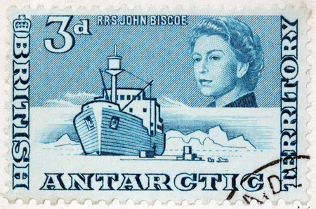 LUGA, RUSSIA - JUNE 25, 2016: A stamp printed by BRITISH ANTARCTIC TERRITORY shows image portrait of Queen Elizabeth II against polar landscape with famous RRS John Biscoe, circa 2013のeditorial素材