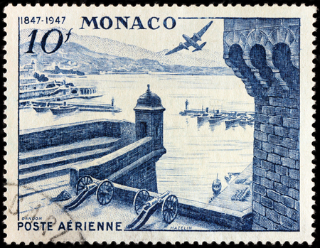 LUGA, RUSSIA - NOVEMBER 29, 2016: A stamp printed by MONACO shows beautiful view of Monte Carlo with Port Hercules, fortress and airplane Douglas DB 7 Boston over Monaco, circa 1947のeditorial素材