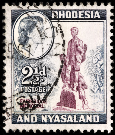 LUGA, RUSSIA - SEPTEMBER 18, 2015: A stamp printed by RHODESIA AND NYASALAND shows image portrait of Queen Elizabeth II against view of Firebridge Memorial, circa 1959のeditorial素材
