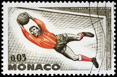 LUGA, RUSSIA - OCTOBER 6, 2017: A stamp printed by MONACO shows football goalkeeper in action, circa 1963のeditorial素材