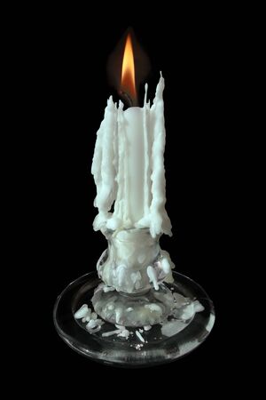 Vintage glass candlestick with burning candle against black background. Selective and soft focus.の写真素材