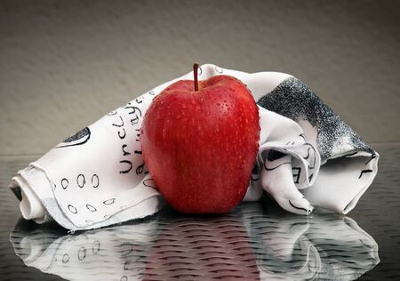 Still life with ripe red apple, black and white napkin with amazing reflectionsの写真素材