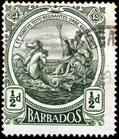 LUGA, RUSSIA - OCTOBER 17, 2017: A stamp printed by BARBADOS shows image portrait of George V, King of England, riding on a chariot across the sea and holding a trident, circa 1925のeditorial素材