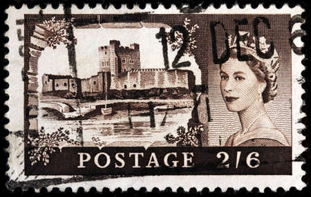 LUGA, RUSSIA - OCTOBER 7, 2017: A stamp printed by GREAT BRITAIN shows portrait Queen Elizabeth II against view of Carrickfergus Castle in Northern Ireland, circa 1958のeditorial素材