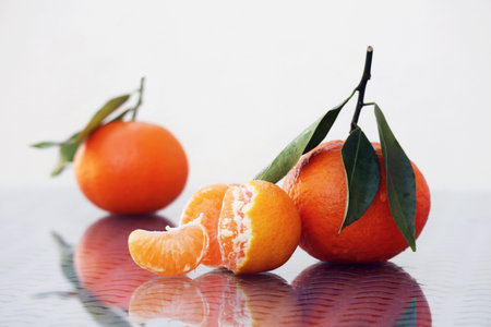 Still life with ripe juicy tangerines with amazing reflections against a high key background....