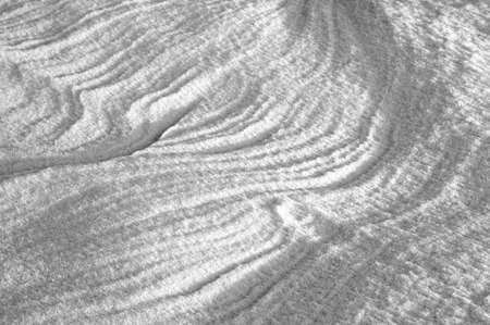 Sleet at a wind sticks to the ground, forming beautiful reliefsの写真素材