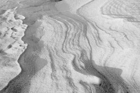 Sleet at a wind sticks to the ground, forming beautiful reliefsの写真素材