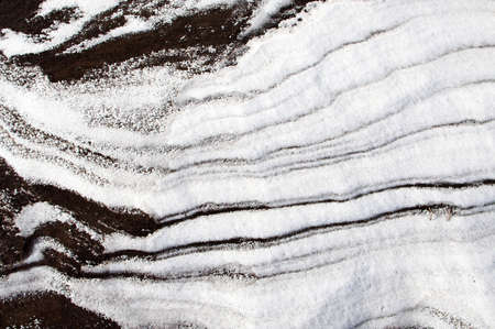 Sleet at a wind sticks to the ground, forming beautiful reliefsの写真素材