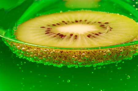 Slice kiwi, floating in water.の写真素材