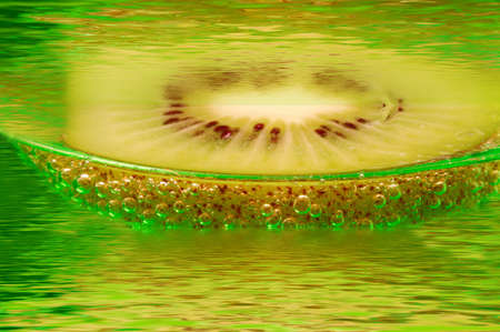 Slice kiwi, floating in water.の写真素材