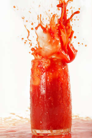 Sparks of tomato juice from a glass on a white background.の写真素材