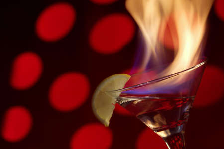 Blue flame of burning alcoholic drinks on a red background.の写真素材