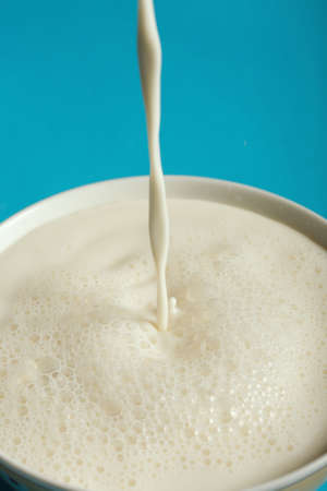 Portion of fresh cow milk on a dark blue backgroundの写真素材