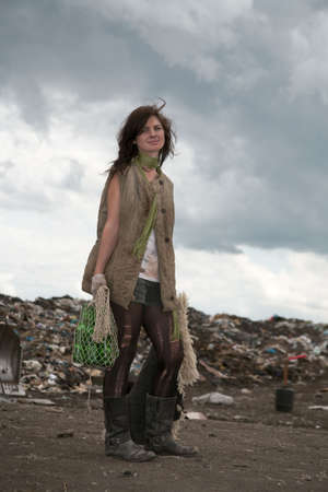 Homeless girl searches for ways of a survival on a city dump.