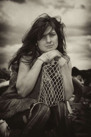 Homeless girl searches for ways of a survival on a city dump.