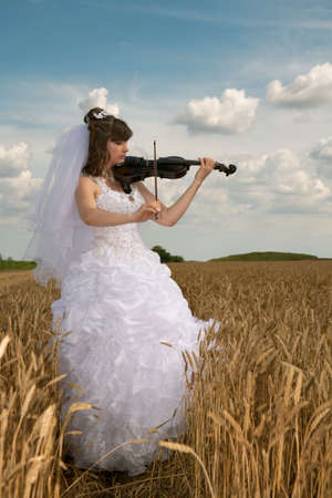 Bride in a wedding dress executes a liked composition on a violinの写真素材