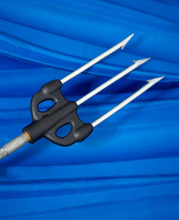Harpoon of a underwater gun on a background foot fins