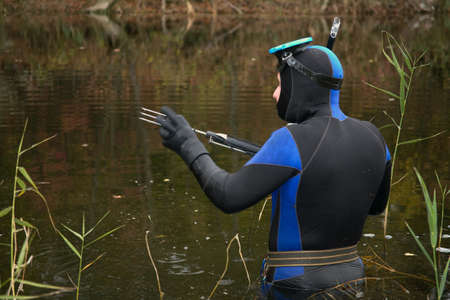 Underwater hunter is immersed in water to hunt .