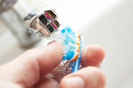 Tooth-brush washing under the crane with waterの写真素材