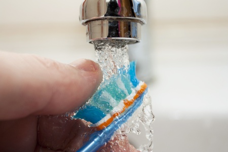 Tooth-brush washing under the crane with waterの写真素材