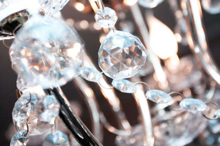 Crystal chandelier with bulbs against a wall