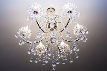 Crystal chandelier with the included bulbs against a wallの写真素材