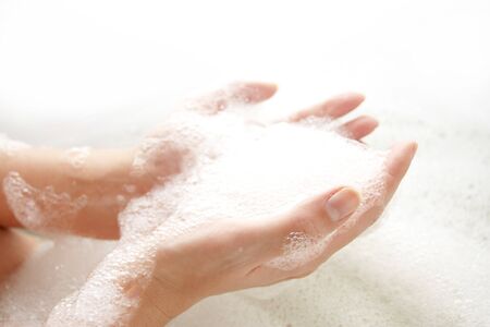 Palms with a soap skin in a bath on a white background